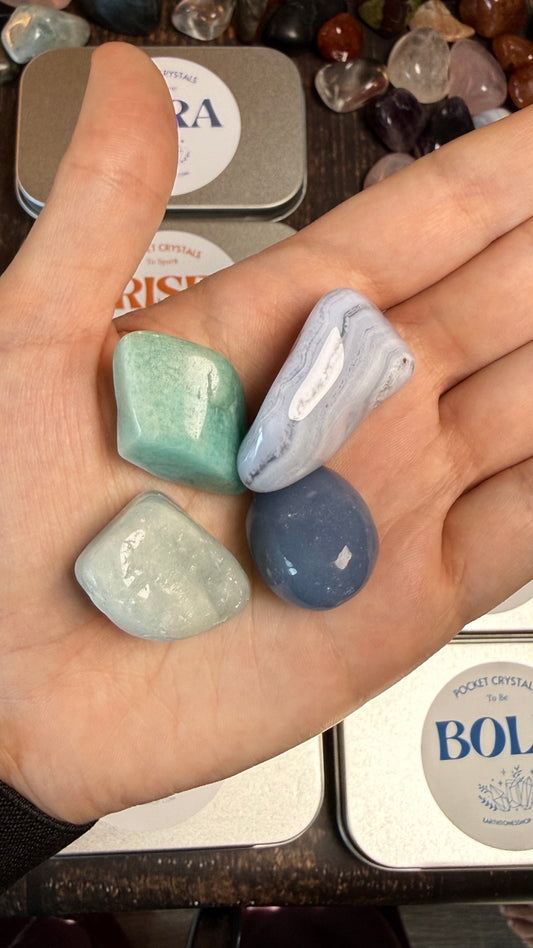 Hand holding four polished stones with a blurred background