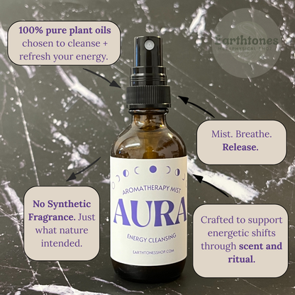 Aromatherapy mist bottle labeled 'Aura' with text about plant oils and energy cleansing on a textured background.