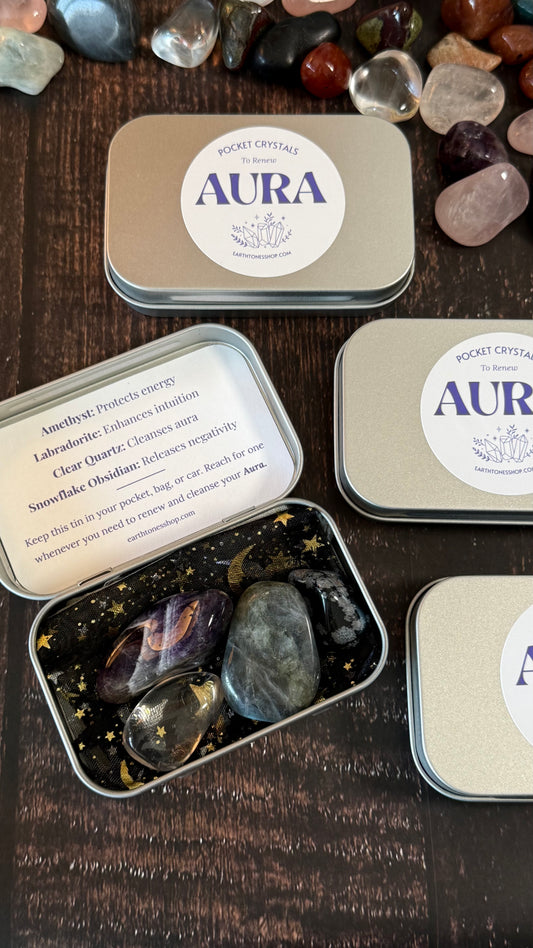 Amethyst, Labradorite, Clear Quartz and Snowflake obsidian in tin on faux wood background 