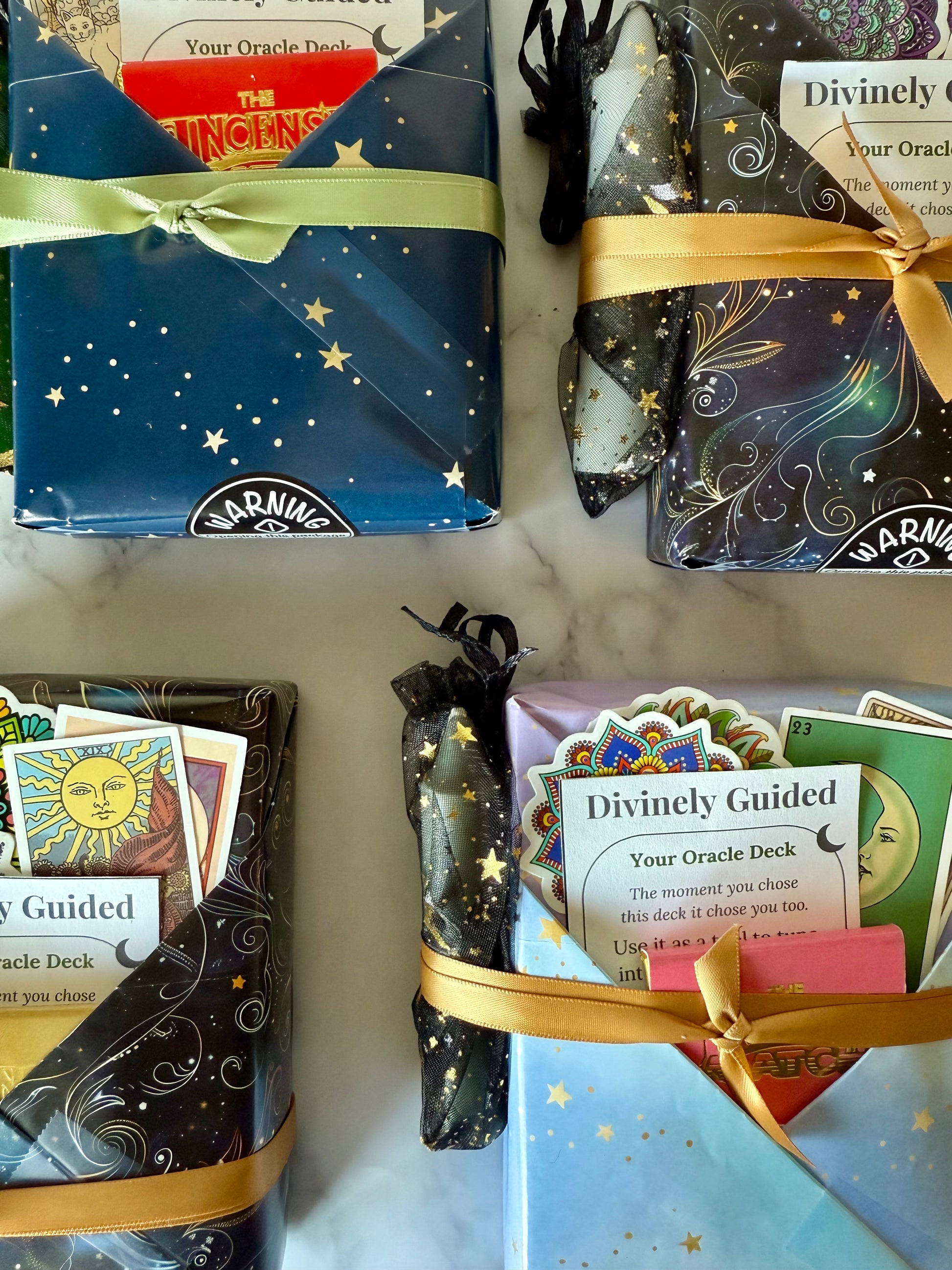 Oracle deck packaging with star designs and gold ribbons on a white surface