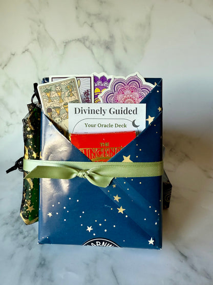 Divinely Guided oracle deck packaging with cards peeking out on a marble surface