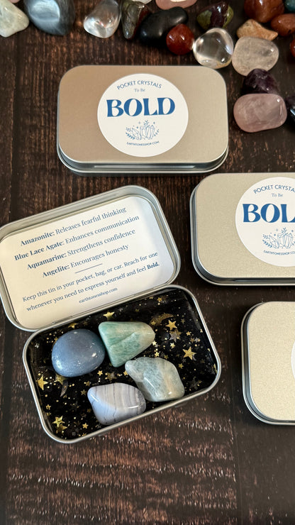 Pocket crystals in tins with 'BOLD' label on a wooden surface
