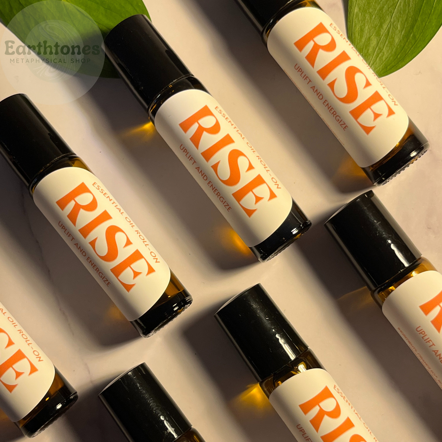 Roll-on bottles labeled 'RISE' on a neutral background