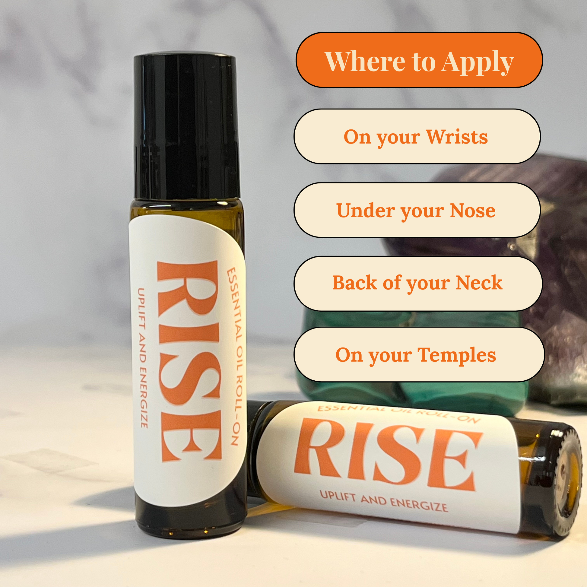 Two bottles of 'RISE' essential oil roll on with application instructions on a neutral background.